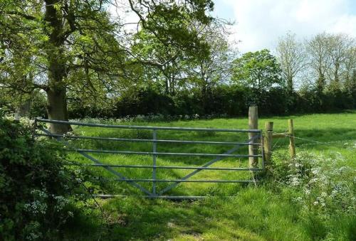 a gate in the middle of a field at Miller's Loft in Erpingham