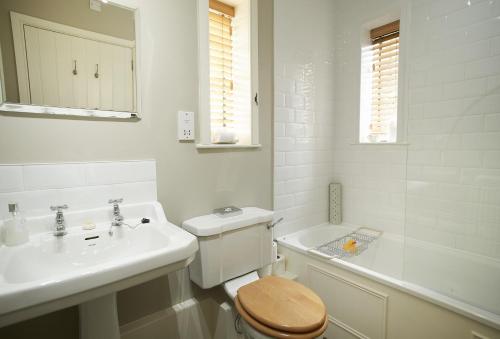 a white bathroom with a toilet and a sink at The Knoll Tower in Weston under Lizard