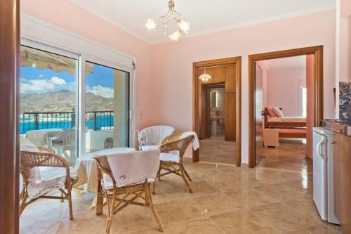a dining room with a table and chairs and a balcony at Crystal Chateau: Μaisonette above the sea in Karpathos Town