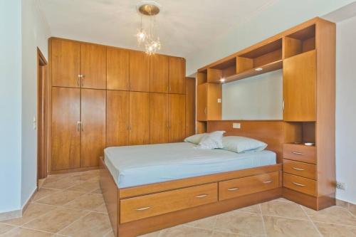 a bedroom with a large bed with wooden cabinets at Crystal Chateau: Μaisonette above the sea in Karpathos Town