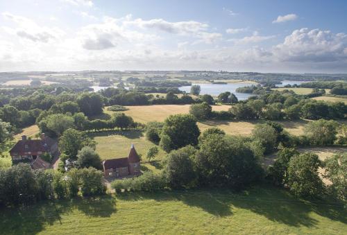 an aerial view of a house in a field with a lake at Bakers Farm Oast in Ticehurst