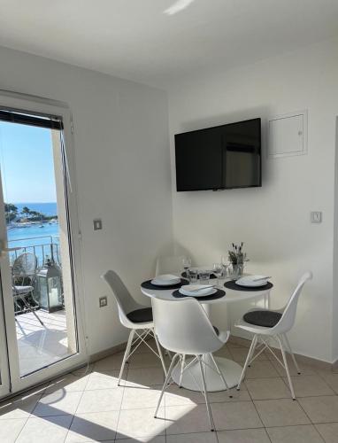 a dining room with a table and chairs and a tv at Apartment Jelka 1 in Krk