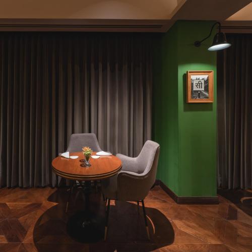 a room with a table and two chairs and a green wall at Taj Theog Resort & Spa Shimla in Shimla
