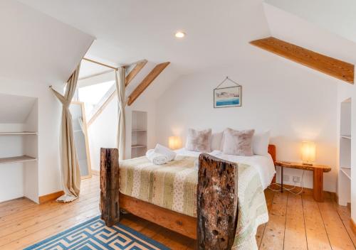 1 dormitorio con 1 cama y suelo de madera en Upper Black Rock, en St Ives