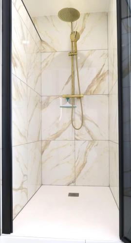 d'une douche avec un mur en marbre blanc. dans l'établissement palou, au Cap d'Agde