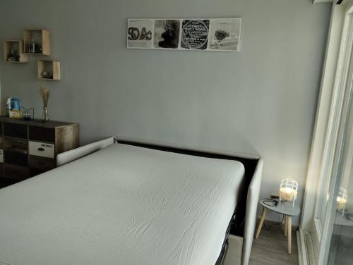 een wit bed in een kamer met een tafel bij Appartement les Rousses Bien situé in Les Rousses