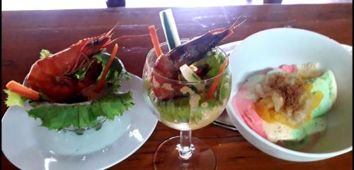 una mesa con dos platos de comida y una copa de vino en Ruis Place, en Vila Praia Do Bilene