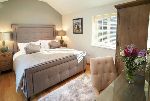 um quarto com uma cama e uma mesa com um vaso de flores em The Cwtch em Pencoed