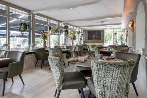een restaurant met tafels, stoelen en ramen bij Het Rechthuis in Uithoorn
