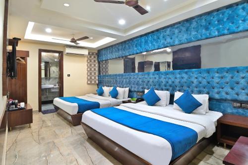 two beds in a hotel room with blue walls at Hotel Vanson Delite - New Delhi Railway Station in New Delhi
