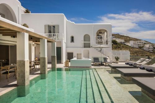 a villa with a swimming pool and a house at Grace Mykonos in Agios Stefanos