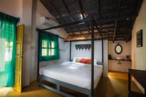 a bedroom with a canopy bed in a room at Craft Hostels in Anjuna