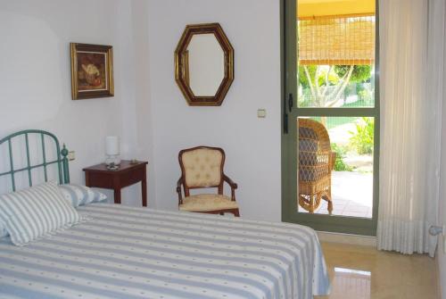 una camera con un letto e una sedia e una finestra di GOLF Y PLAYA EN SAN JUAN ad Alicante