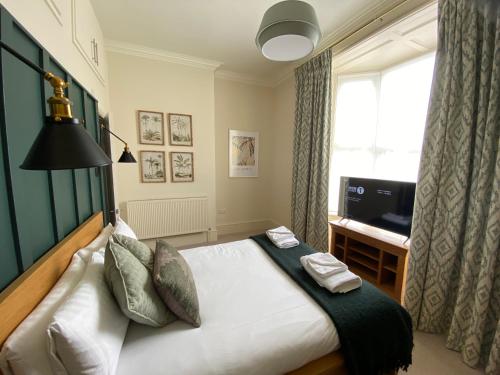 a bedroom with a bed and a television and a window at Brayford House in Lincoln