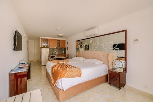 a bedroom with a large bed and a kitchen at Muthu Clube Praia da Oura in Albufeira