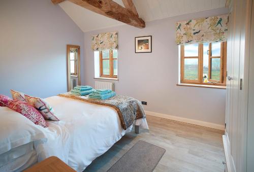 a bedroom with a bed and a window at Little Owls Barn in Little Cowarne