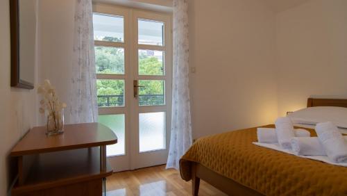 a bedroom with a bed and a large window at Mozart apartments in Baška Voda