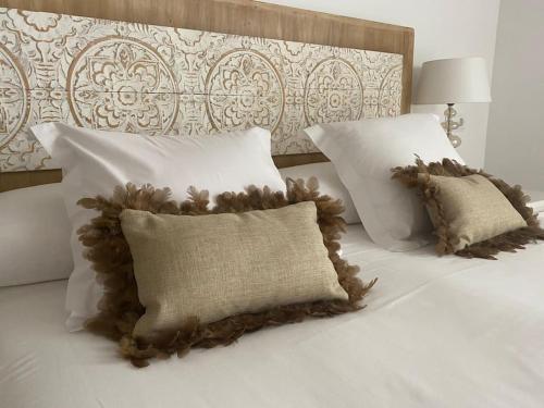 a bed with white pillows and a headboard with two pillows at Fantastico Tarragona Corsini Apartment-1, en el centro con parking in Tarragona