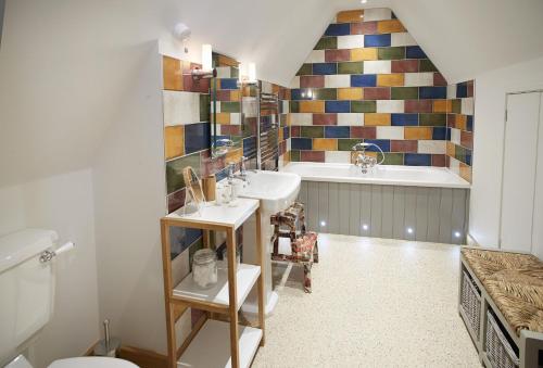 een badkamer met een wastafel en een bad bij Rosebank Barn in Bibury
