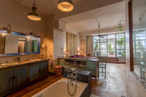 タリファにあるBOMBAYARTE APARTHOTEL TARIFAの広いバスルーム(バスタブ、シンク2台、カウンター付)