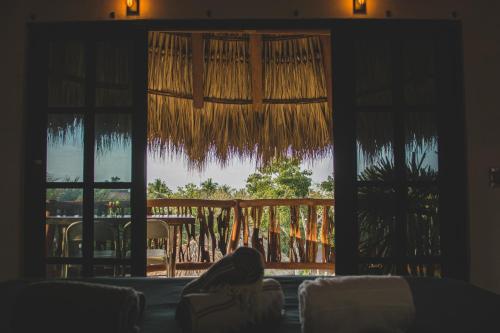 a person sitting on a couch looking out of a window at Villas Oasis, Troncones in Troncones