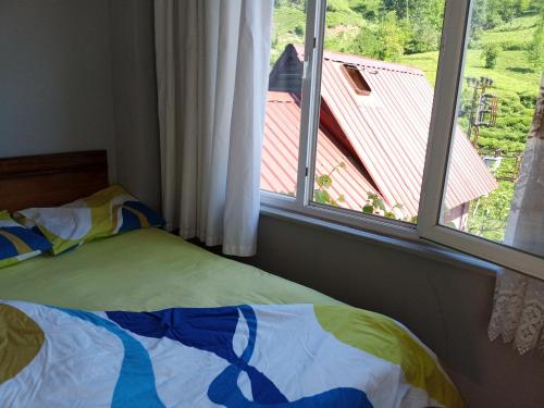 Schlafzimmer mit einem Bett und einem Fenster mit Aussicht in der Unterkunft Nokta evler 
