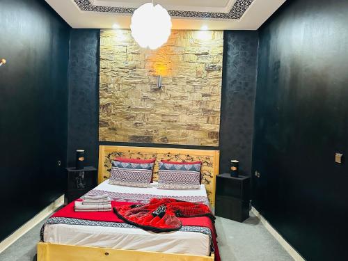 a bedroom with a bed with a stone wall at The Best Stop in Midelt