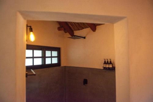 a hallway to a room with a window and bottles of wine at Villas Oasis, Troncones in Troncones