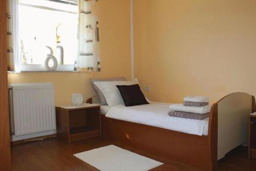 a small bedroom with a bed and a window at Apartments Fičur with Swimming Pool & Grill, Portorož in Portorož