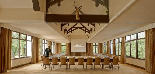 a large room with a table and chairs and a clock at Fairmont Mount Kenya Safari Club in Nanyuki