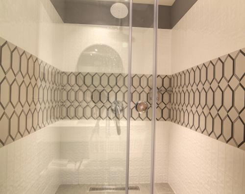 a shower with a glass door in a bathroom at 7 Apple Hotel Pratap Nagar, Jaipur in Jaipur