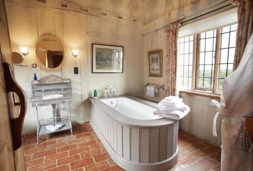 een grote badkamer met een bad en een wastafel bij Elinor Fettiplace in Pauntley