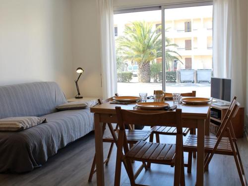 un salon avec une table et un canapé dans l'établissement Appartement T2 avec terrasse, parking privé, proche plage et commerces - FR-1-229C-9, à Port-la-Nouvelle