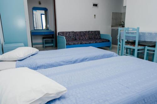 a room with two beds and a living room at Cleopatra Studios in Marathokampos