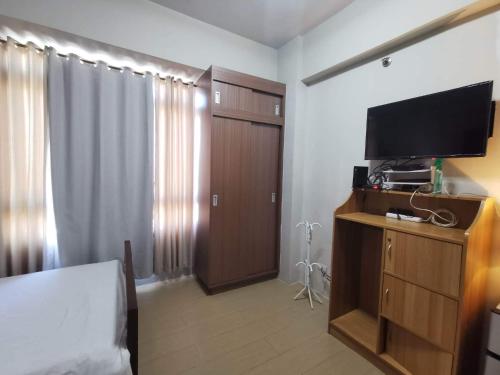 a room with a bedroom with a tv on a dresser at Entire Home @150NB pasay city in Manila