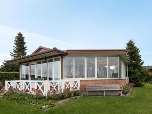 a small house with a bench in the grass at Holiday Home Eleana - 300m to the inlet in Sealand by Interhome in Roskilde