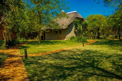 a house with a brick path leading to a yard at Mela Luxury Game Lodge in Pretoria