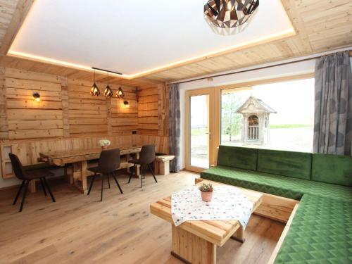 a living room with a green couch and a table at Apartment Tristner Appart by Interhome in Schwendau