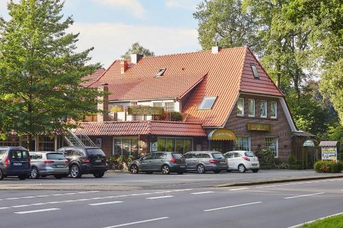 a building with cars parked on the side of a street at Flairhotel Hubertus in Bad Zwischenahn