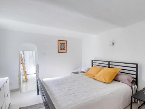 - une chambre blanche avec un lit et des oreillers jaunes dans l'établissement Apartment Mimosa by Interhome, à Six-Fours-les-Plages