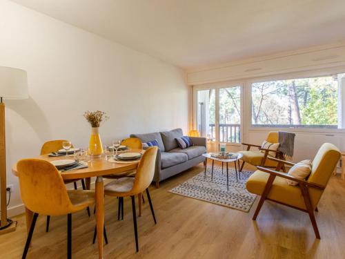 un salon avec une table, des chaises et un canapé dans l'établissement Apartment Le Bourret-3 by Interhome, à Soorts-Hossegor