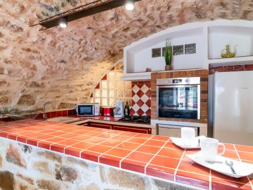 - une cuisine avec un comptoir en carrelage blanc et orange dans l'établissement Apartment La Bergerie de Sainte Croix by Interhome, au Thoronet
