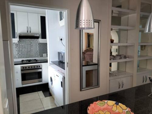 a kitchen with white cabinets and a stove top oven at Caribbean Estates Villa 7B in Port Edward