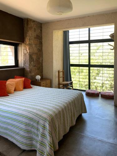 a bedroom with a large bed with orange pillows at La Molicie, Achiras Arriba in San Javier