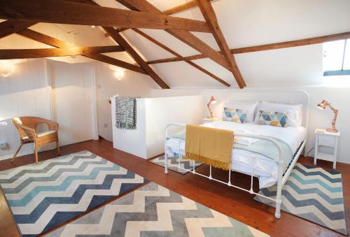 a bedroom with a bed and a chair and a rug at Seekings Cottage in Knowstone