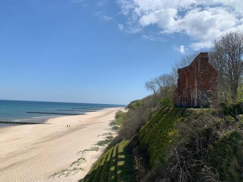 a building on a hill next to a beach at HUS - caloroczne komfortowe szeregi blisko plazy in Pobierowo