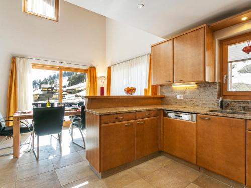 a kitchen with wooden cabinets and a dining table at Chalet Martens by Interhome in Les Crosets