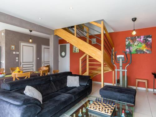 un salon avec un canapé noir et un échiquier dans l'établissement Holiday Home Portsall Paradise by Interhome, à Ploudalmézeau