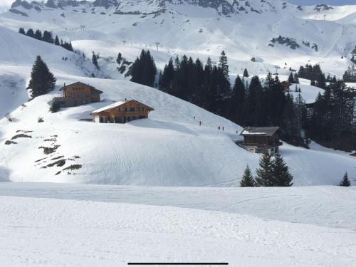 a snow covered slope with houses on a mountain at Chalet Martens by Interhome in Les Crosets