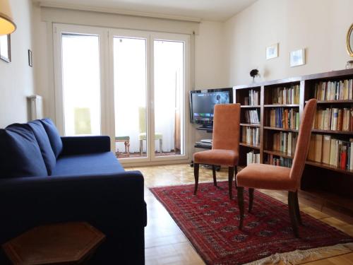Apartment Pérolles by Interhome في فريبورغ: غرفة معيشة مع أريكة وكرسيين